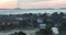 Beautiful peaceful top view summer countryside panorama at sunrise. Residential cottages among green trees covered with blue