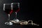 Beautiful Pearl Necklace and Two Glass Cups of Red Wine Isolated on Black