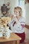 Beautiful peasant woman in embroidered clothes drinks tea in an old Ukrainian hut