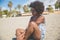 Beautiful pensive afro american woman sitting on beach