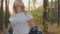 Beautiful pensive girl walking in forest and looking aside