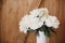 Beautiful peony bouquet in white ceramic vase on rustic wooden background. Stylish white peonies rural still life. Hello spring