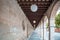 A Beautiful Perspective of an Aisle with Brick Walls on the left, Arches and Garden on the right and Stripes of Wooden Ceiling on