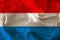 Beautiful photo of the colored national flag of the modern state of Luxembourg on textured fabric, concept of tourism, emigration