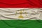 Beautiful photo of the colored national flag of the modern state of Tajikistan on textural fabric, concept of tourism, emigration