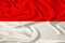 Beautiful photo of the national flag of Monaco and Indonesia on delicate shiny silk with soft draperies, the concept of state