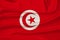 Beautiful photo of the national flag of Tunisia on delicate shiny silk with soft draperies, the concept of state power, country
