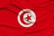 Beautiful photo of the national flag of Tunisia on delicate shiny silk with soft draperies, the concept of state power, country