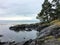Beautiful photo of a picturesque rocky shoreline surrounded by evergreen forest and a vast ocean