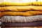 Beautiful photo of a pile of knitted yellow woman sweaters. Woman fashion. Autumn clothing.