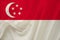 Beautiful photograph of the national flag of Singapore on delicate shiny silk with soft draperies, the concept of state power,