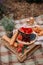 A beautiful picnic in nature with fruit, bakery and a bottle of rose wine. A wooden table, a plaid in a cage and a decor of