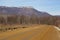 Beautiful pictorial landscape of stretching into distance of mountain road with trees outlines of powerful mountains