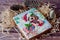 Beautiful picture on holiday honey cookie, glazed by different colors , laying on wooden background near pine cones