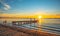 Beautiful picture of a vintage wooden bridge in an ocean against a mesmerizing sunset