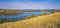 Beautiful picturesque landscape scenic view from above hill grass land with peaceful natural reservoir water in the middle summer