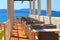 Beautiful picturesque summer view of a cafe with white columns by the sea. Brown tables against the backdrop of the Croatian sea