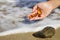 Beautiful pieces of amber in the hand of the sea background. A glowing wavy piece of amber in the palm of your hand. The