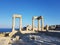 Beautiful pillars of a old ruined building located on the coast of a calm sea against a cloudless blue sky.