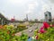 Beautiful pink Bougainvillea flower with the view of Victory Monument at the center of a traffic circle at the intersection.