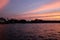 Beautiful pink clouds over the river. Temple tower at sunset