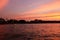 Beautiful pink clouds over the river. Temple tower at sunset