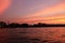 Beautiful pink clouds over the river. Temple tower at sunset