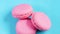 Beautiful pink cookies or macaroons are laid out on a blue bed background. Slow camera movement.