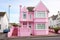 A beautiful pink dollhouse building. The cottage of a princess girl. The doll mansion. A woman's house in an