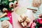 Beautiful and pink notebooks and flowers on a white wooden background with clothespins and gift in spring