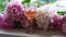 Beautiful pink Peonies flowers and glass of white wine on windowsill against countryside background.