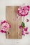 Beautiful pink, rose peonies on wood plate