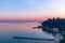 Beautiful pink sunset on Lake Garda. View of the embankment and piers of the city of Sirmione. Winter time on the lakes of Italy