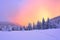 Beautiful pink sunset shine enlightens the picturesque landscapes with fair trees covered with snow.