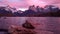 Beautiful pink sunset with view on mountain lake with scenic rocks on first plan in Torres del Paine Park in Patagonia.