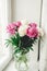 Beautiful pink and white peonies bouquet at rustic old wooden window. Floral decor and arrangement. Gathering flowers. Rural still