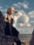 Beautiful pirate woman standing on the beach in boots.