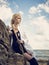 Beautiful pirate woman standing on the beach in boots.