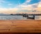 Beautiful plank wooden table, desk or floor. Blurred background of sunset at sea and local fishing boat. Colourful light on sky.