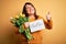 Beautiful plus size woman celebrating mothers day holding best mom message and tulips happy with big smile doing ok sign, thumb up