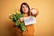 Beautiful plus size woman celebrating mothers day holding best mom message and tulips pointing with finger to the camera and to