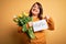 Beautiful plus size woman celebrating mothers day holding best mom message and tulips with surprise face pointing finger to