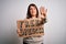 Beautiful plus size woman holding free speech banner for rights protest over isolated background with open hand doing stop sign