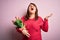 Beautiful plus size woman holding romantic bouquet of natural tulips flowers over pink background crazy and mad shouting and