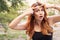 Beautiful plus size woman squeezing pimple on her forehead using her hands. Summer outdoor portrait, copy space