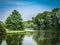 Beautiful pond with different trees around and blue sky