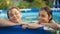 On beautiful pool, summer great time. Girl and boy, brother and sister plays in pool