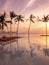 Beautiful poolside and sunset sky. Luxurious tropical beach landscape, deck chairs and loungers and water reflection