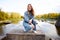 Beautiful portrait of a 90s redhead scandinavian teenager girl in jeans in a park near a lake