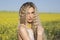 Beautiful portrait of a countryside girl posing over yellow field background.